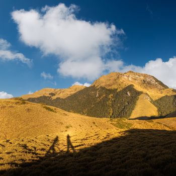 Mountain with shadow of cameraman under the beautiful sky.