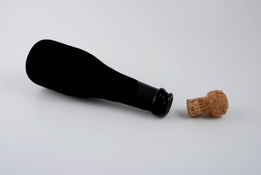 Pictures of an empty bottle of champagne with the cork at it side