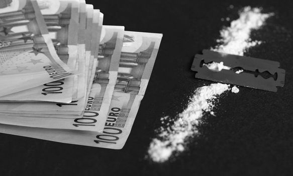 Cocaine, razor blade and money (simulation using wheat flour, no actual drugs used)