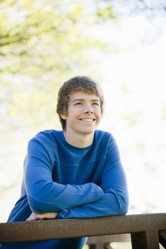 Portrait of a Smiling Teenage Boy Leaning on Railing