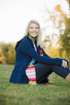 Portrait of a Pretty Blond Teen Girl Sitting in a Park