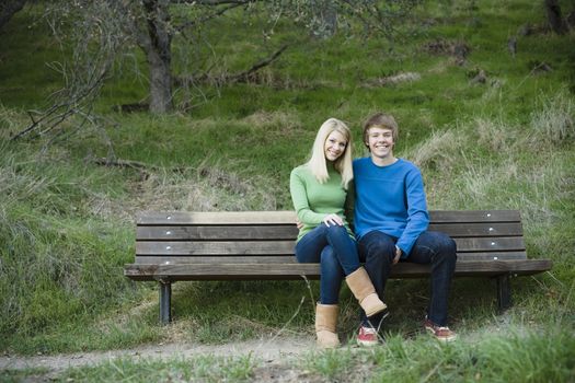 Portrait of a Brother and Sister Sitting on Bench in a Park