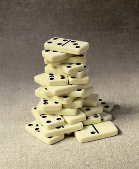 High tower consisting of dominoes against a drapery