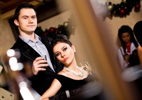 Female and male holding glasses with drink in casino