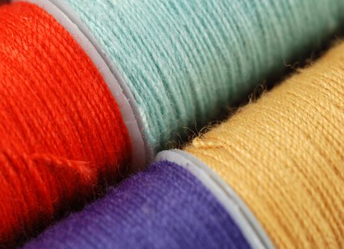 colorful spools of multi colored threads for sewing and knitting