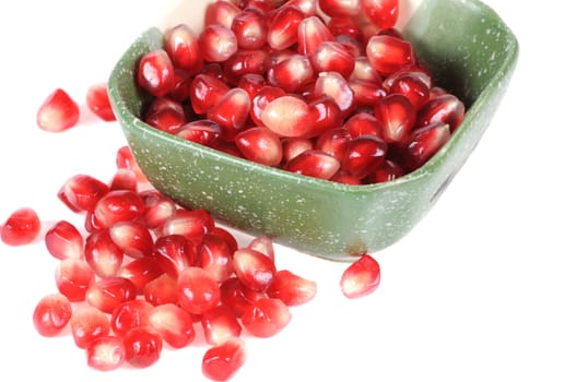 Pomegranate grains in a plate isolated on white background