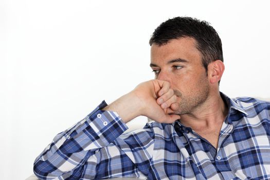 pensive man with blue shirt at home