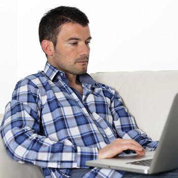 relaxed man sitting on sofa with computer