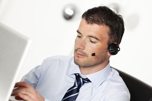 man in office with headset and computer