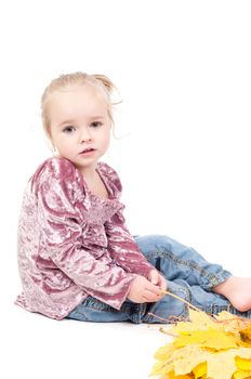 Shot of toddler playing with muple leaves in studio