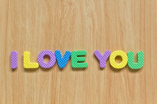 colorful letters with "I love you" isolated on wood texture