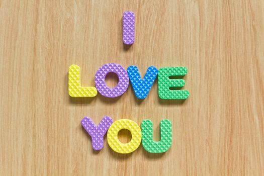 colorful letters with "I love you" isolated on wood texture