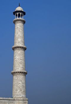 White marble tower isolated against blue sky.
