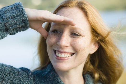 Portrait of a Pretty Redhead Woman Shielding Her Eyes