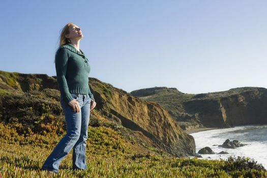 Portrait of a Pretty Redhead Woman on Cliffside With Head Facing up to Sky