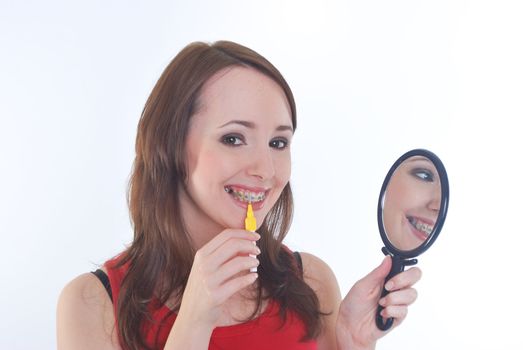 pretty girl with braces cleaning teeth