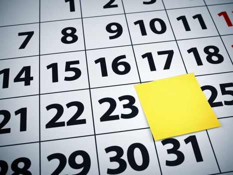 Close up of a blank sticky note on a calendar.