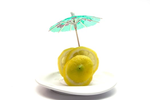 Yellow juicy lemon on a white plate on a white background