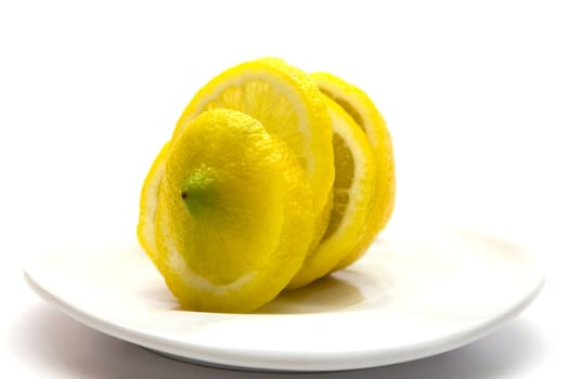 Yellow juicy lemon on a white plate on a white background