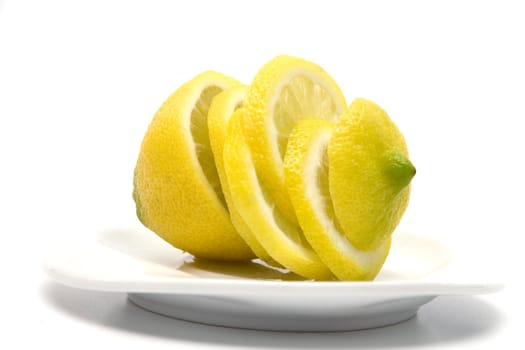 Yellow juicy lemon on a white plate on a white background