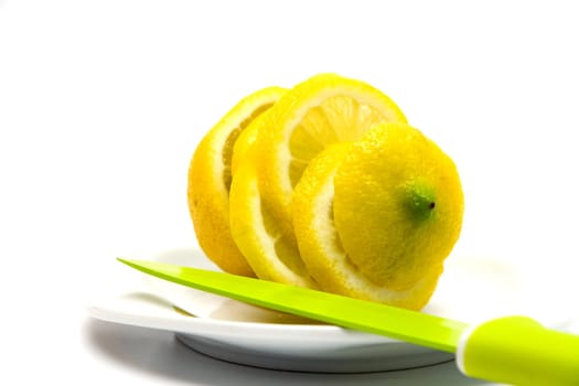 Yellow juicy lemon on a white plate on a white background