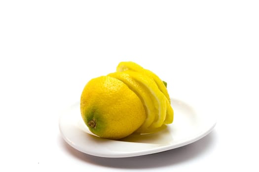 Yellow juicy lemon on a white plate on a white background