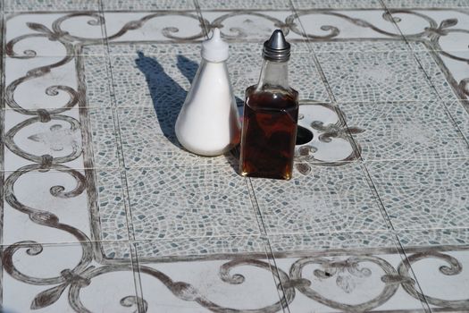 Salt and vinegar jars on tile table