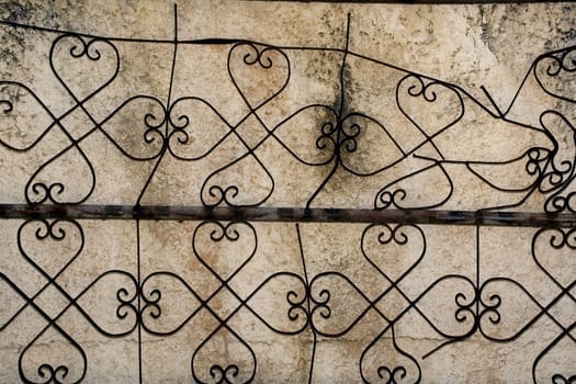 Patten iron design against a weathered concrete wall