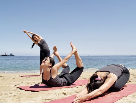 Young female yoga teacher practising at beach duplicated three times