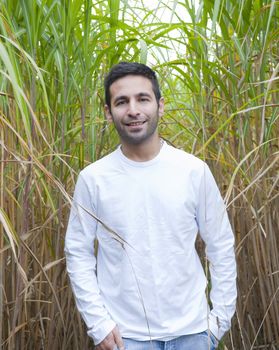 Man standing ina field of Bamboo smiling