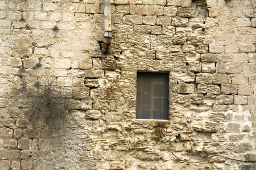 The exposed to the wind wall of an old building constructed from calcareous bricks