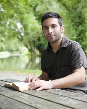 Man reading beside a canal