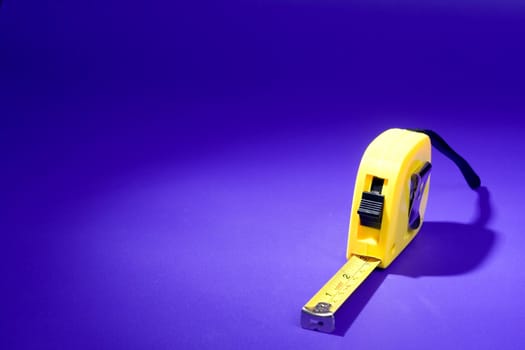 Yellow measurer  tape on blue background 