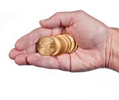 Male hand holding a stack of pure gold eagle coins