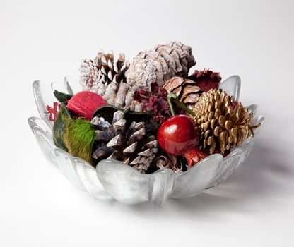 Christmas or thanksgiving decoration with scented cones and nuts in a glass vase