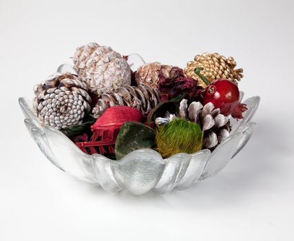 Christmas or thanksgiving decoration with scented cones and nuts in a glass vase