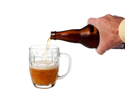 Golden ale being poured from brown bottle into half full english pint mug