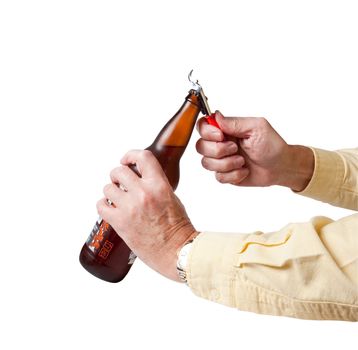 Bottle cap being removed from brown cold beer bottle