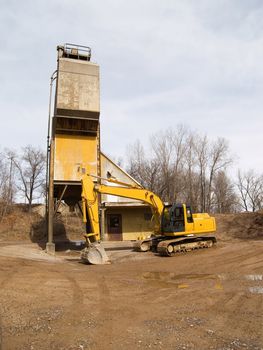 Excavator near a cement silo
