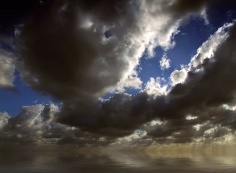 Clouds looming over the horizon with rays seeping through cast