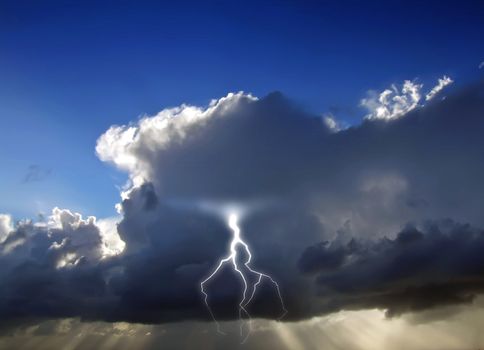 Clouds looming over the horizon with rays seeping through cast