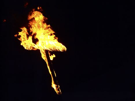Burning crosses being used as part of ritual, on black background