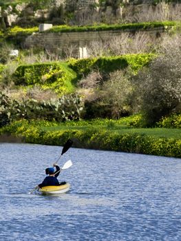 Young children canoeing in a rainwater river in Malta