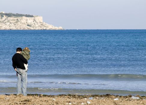 Father and little daughter standing by the coast in Malta.