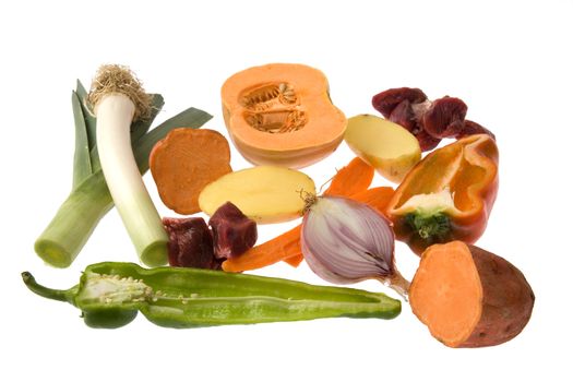 Pieces of  peppers, leeks, onion, potatoes and sweet potatoes, pumpkin, carrots and veal meat isolated over white.