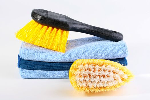 Two brushes for cleaning of a premise and a set of soft rags in a dark blue tonality.