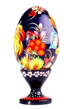 Wooden painted egg in style of Russian varnish list on a support. On egg flowers a symbol of the Russian village are drawn.