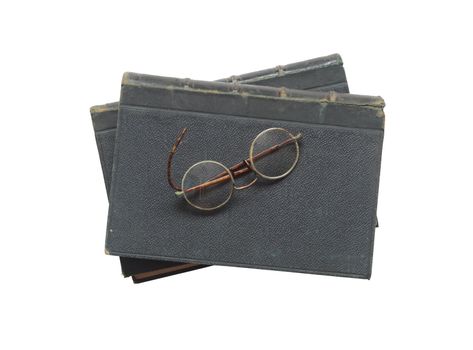 Stack of ancient books and spectacles on white background isolated with clipping path