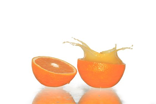 Sliced orange and splash of juice isolated on white background with clipping path