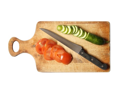 Sliced vegetables and kitchen knife on wooden breadboard. Isolated with clipping path